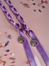Load image into Gallery viewer, Intertwined Handfasting Cord made from mauve, lilac and lavender strands of satin ribbon, along with silver tree of life charms. Set against a pink backdrop with confetti.