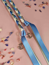 Load image into Gallery viewer, Intertwined Handfasting Cords made from blue, ivory and green strands of satin ribbon, along with silver anchor charms. Set against a pink backdrop with confetti.