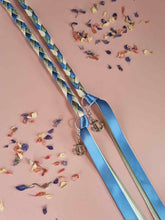 Load image into Gallery viewer, Intertwined Handfasting Cords made from blue, ivory and green strands of satin ribbon, along with silver anchor charms. Set against a pink backdrop with confetti.