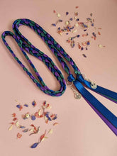 Load image into Gallery viewer, Intertwined Handfasting Cord made of blue, green and purple strands of satin ribbon, along with silver thistle charms.